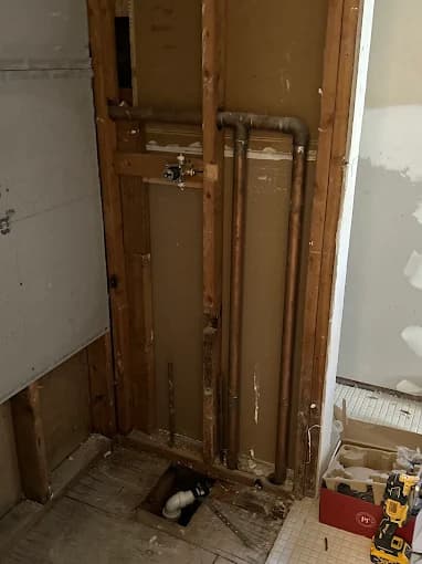 Copper plumbing rough-in inside a stripped wall cavity