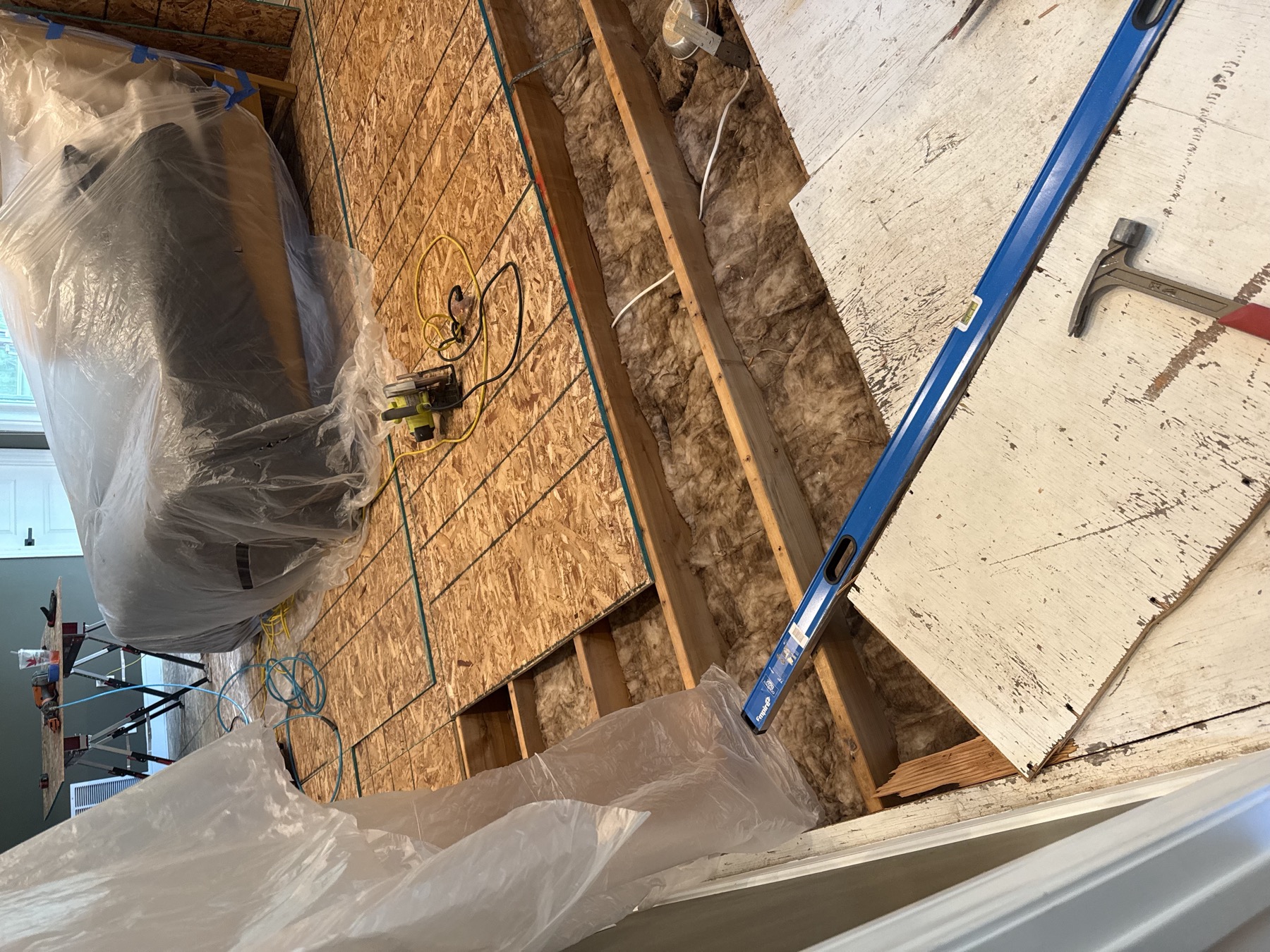 Interior renovation with protected furniture and subfloor panels being installed